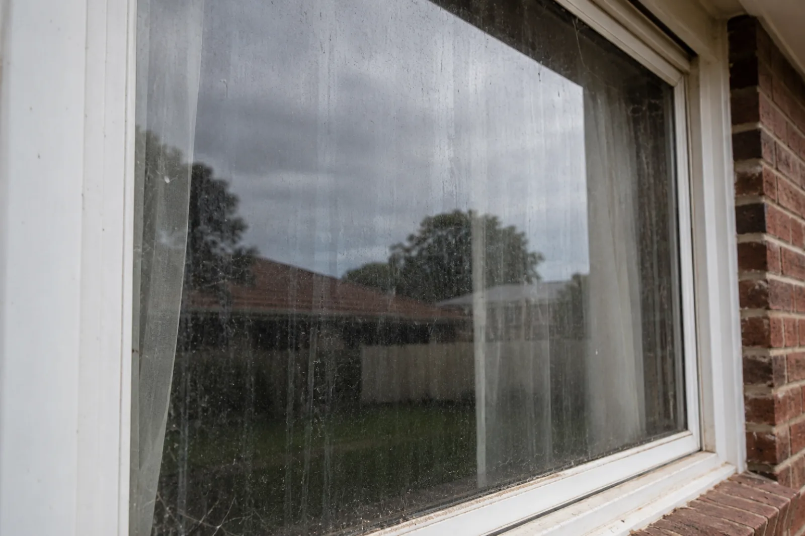 Exterior window before cleaning — dust, water spots and streaks visible